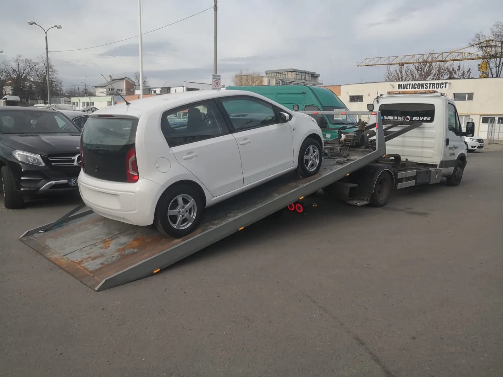 Tractări auto Galați — autoturism mic urcat pe platformă, într-o parcare din Galați.